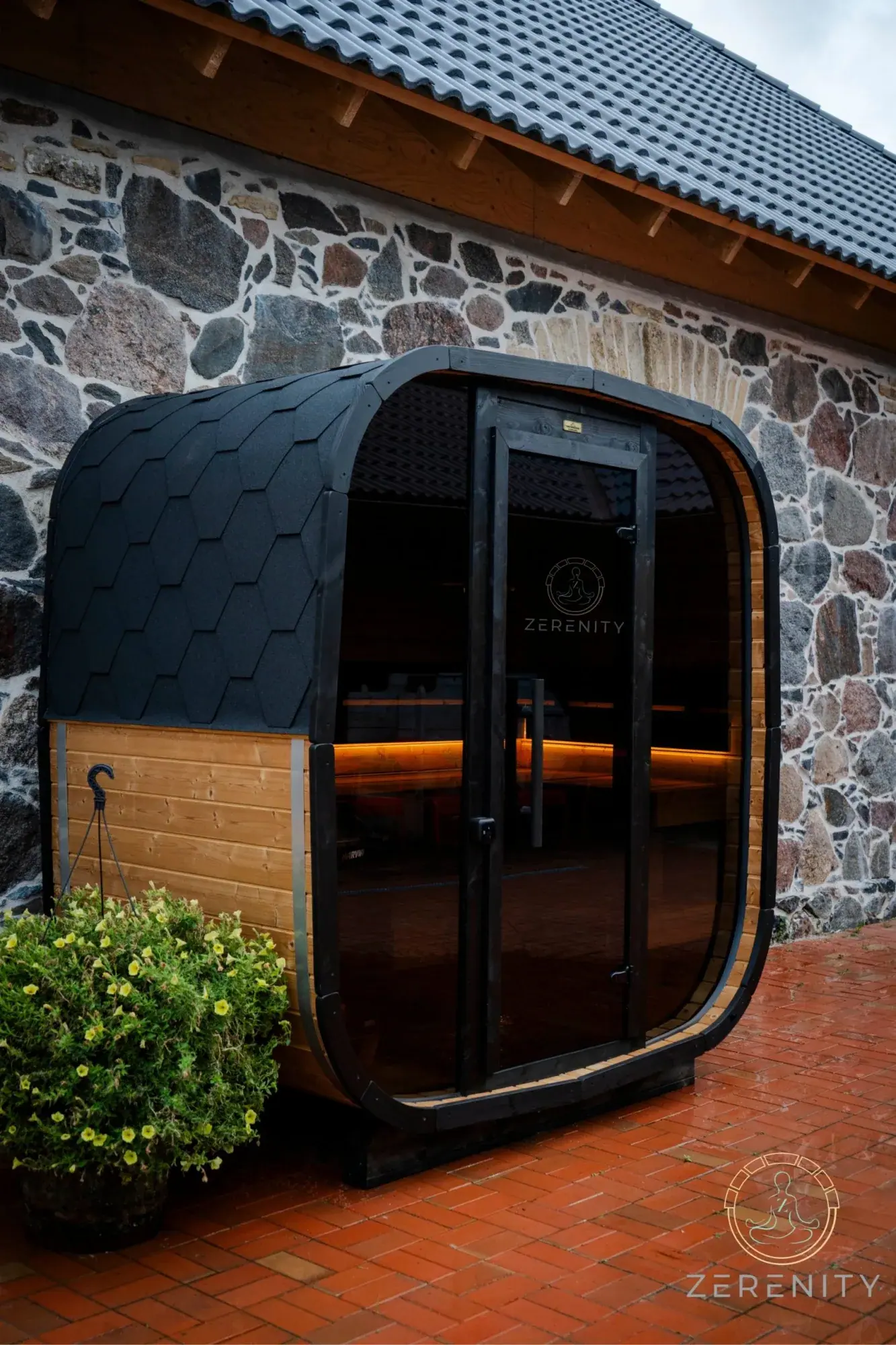 Zerenity Koda sauna installed against a stone building